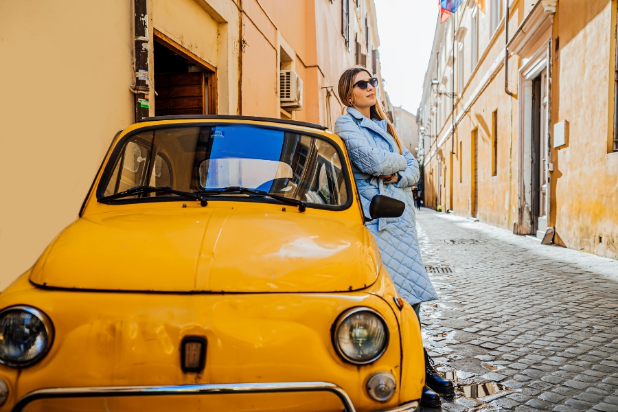 בחורה עם רכב שכור צהוב באיטליה.